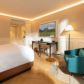 Detail of hotel room with reading chair, working desk and smart TV