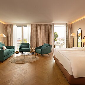 Spacious and bright Junior Suite with double bed, sofa and two chairs