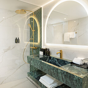Elegant bathroom with washbasin, mirror and walk-in rain shower