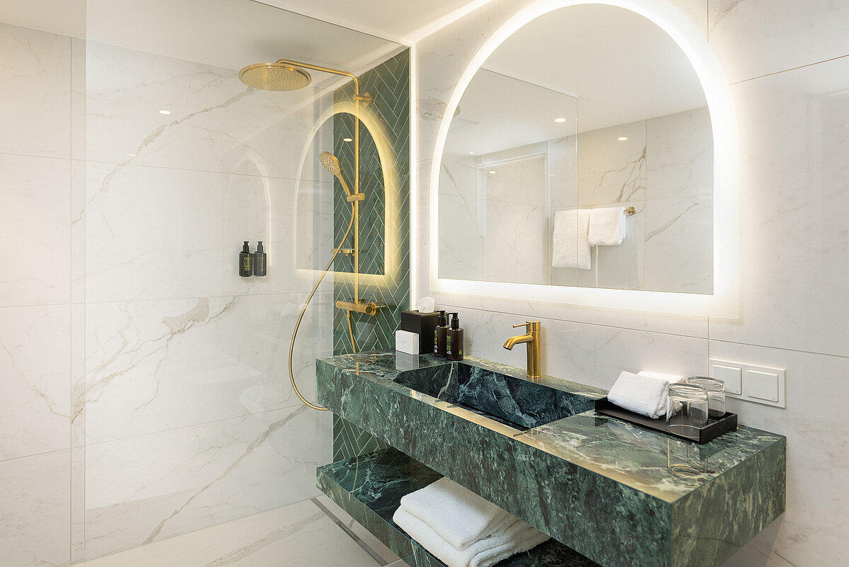 Elegant bathroom with washbasin, mirror and walk-in rain shower