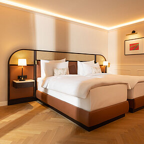 Hotel room with oval wall mirror and twin beds