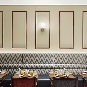 Restaurant mit gedeckten Tischen im Grand Hotel Savoy