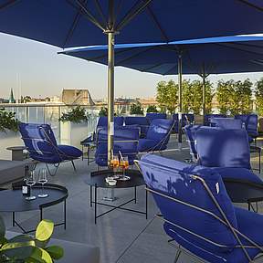 Terrasse mit Schirm und Stühlen im Grand Hotel Savery