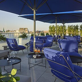 Terrasse mit Schirm und Stühlen im Grand Hotel Savery