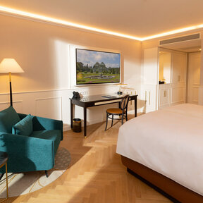 Bright hotel room with work desk, chair, and floor lamp