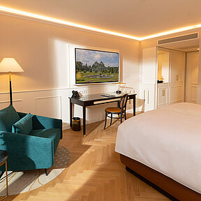 Bright hotel room with work desk, chair, and floor lamp
