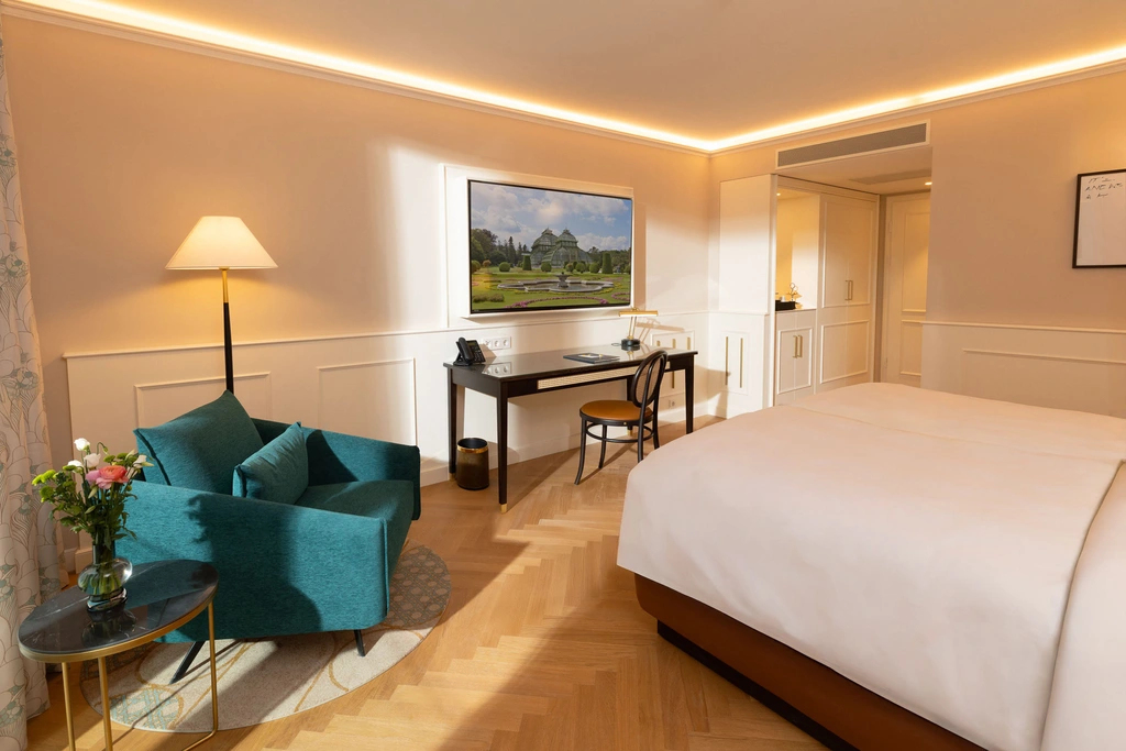 Bright hotel room with work desk, chair, and floor lamp