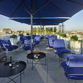 Terrasse mit Schirm und Stühlen im Grand Hotel Savery