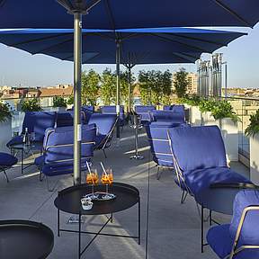 Terrasse mit Schirm und Stühlen im Grand Hotel Savery