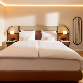Elegant hotel room with king-size bed and classic parquet flooring