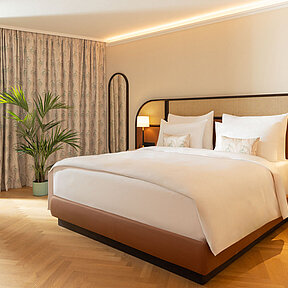 Large hotel room with king-size bed at EST Hotel Palais Chotek