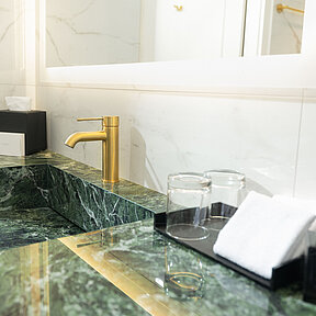 Hotel bathroom detail: elegant washbasin with marble finish