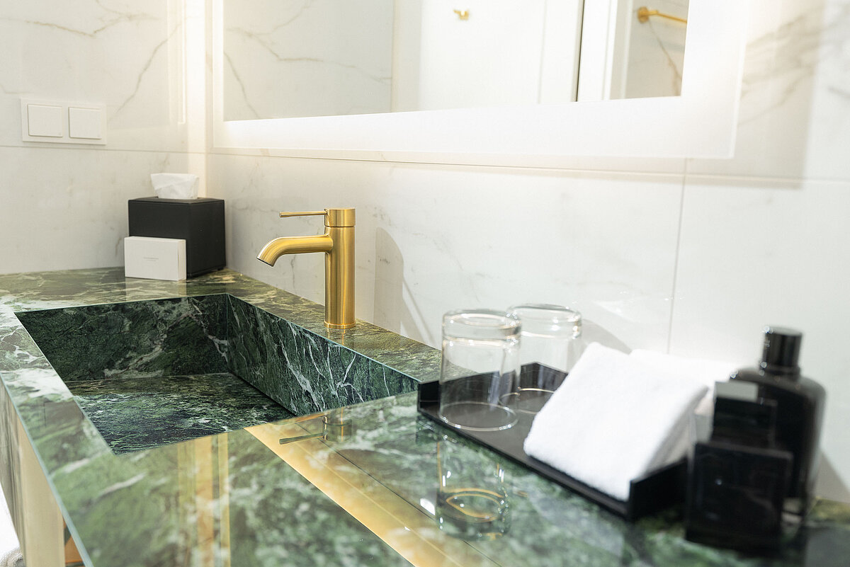 Hotel bathroom detail: elegant washbasin with marble finish