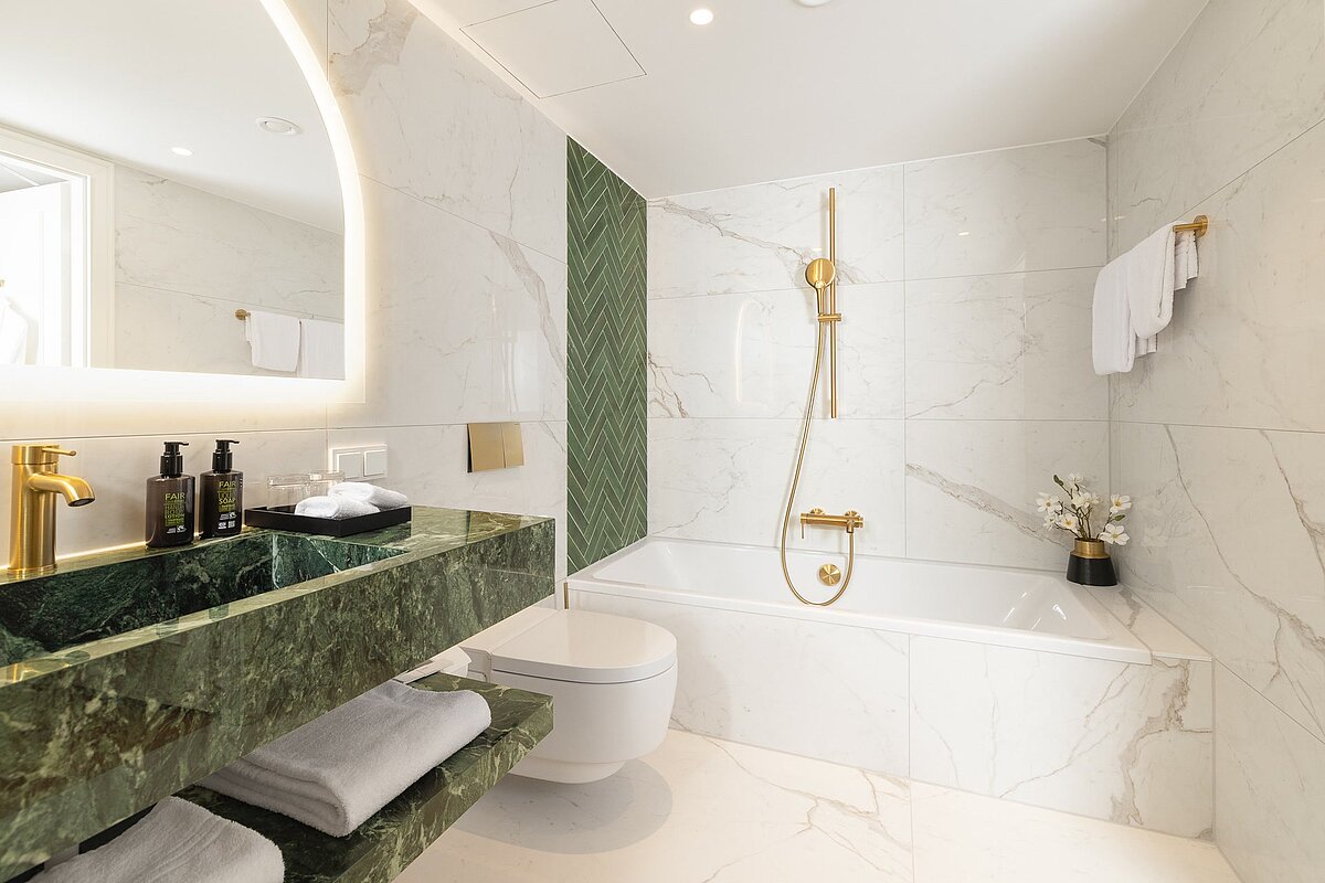 Spacious bathroom with bathtub and shower at Junior Suite