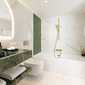 Spacious bathroom with bathtub and shower at Junior Suite
