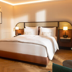 Hotel room with king size bed and classic parquet flooring