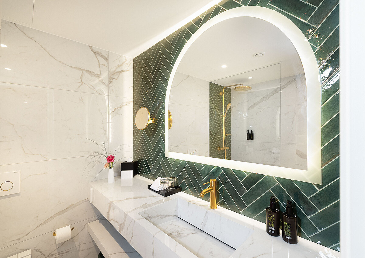 Hotel bathroom vanity with backlit mirror