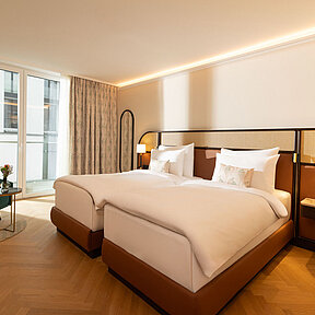 Bright twin-bedded hotel room with cosy reading chair