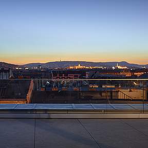 die Terrasse am Abend mit Sicht auf die Stadt