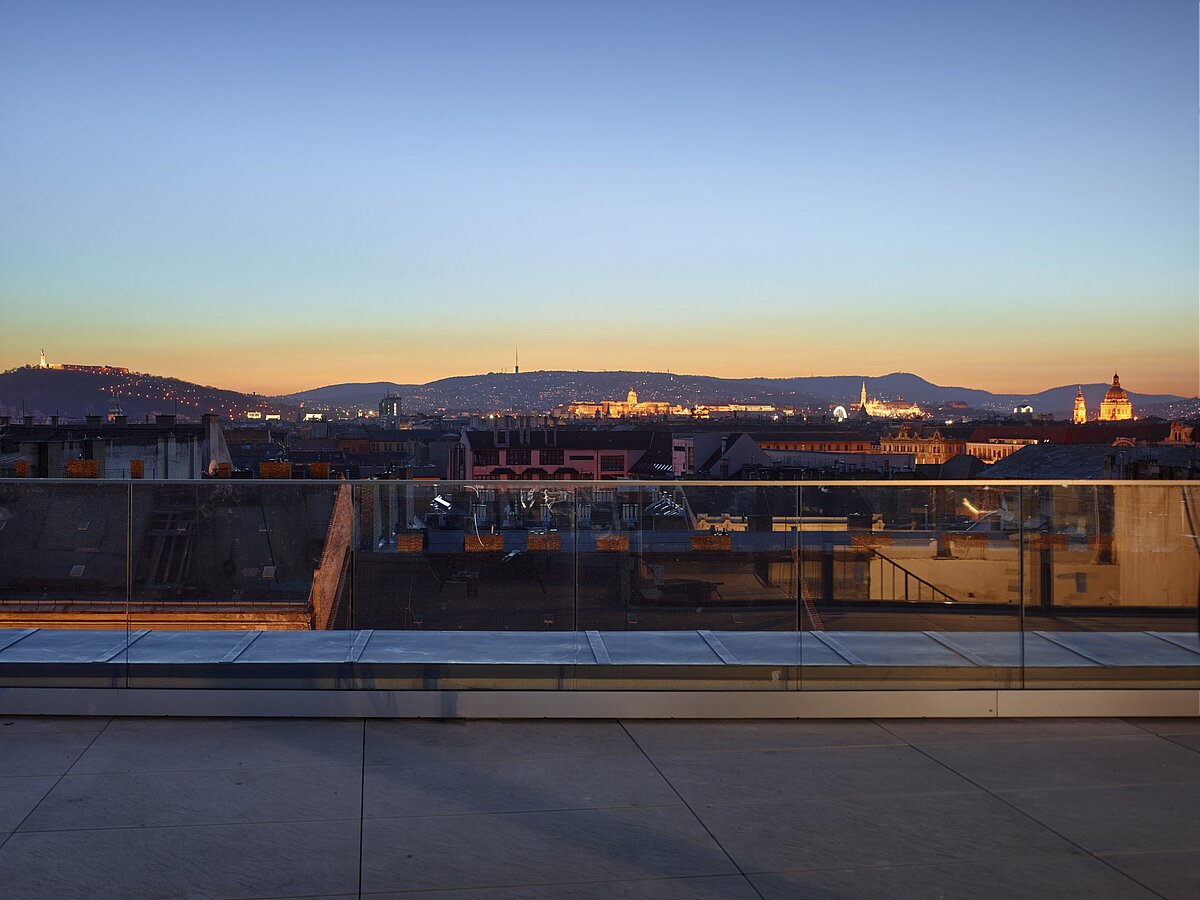 die Terrasse am Abend mit Sicht auf die Stadt