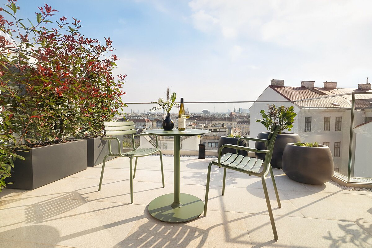 Roof top terrace with table and chairs and view over Vienna